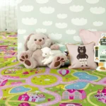 Kids' playroom featuring a pink and green village road map carpet with plush toys.