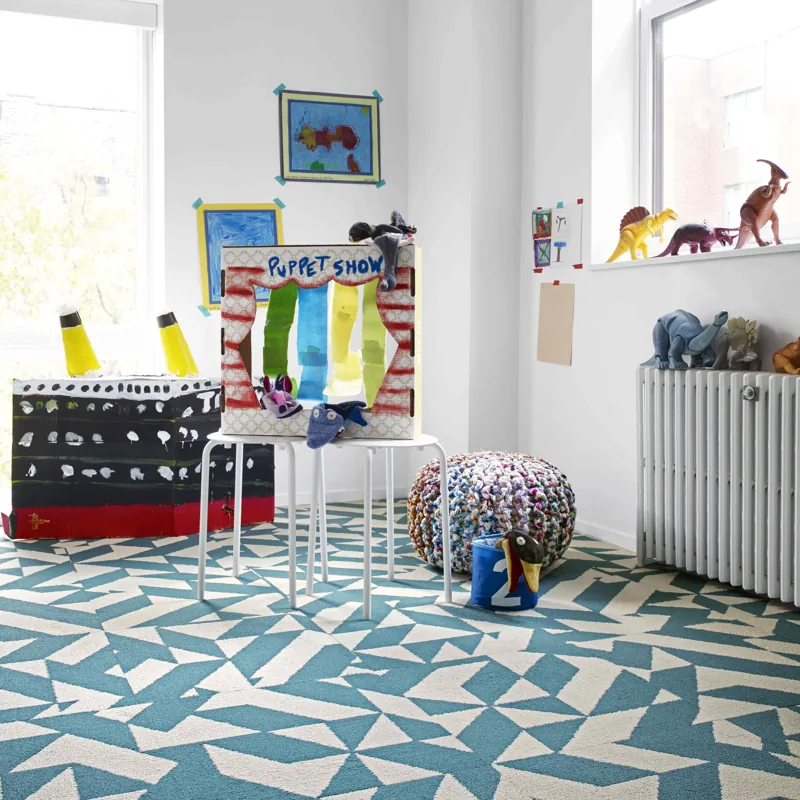 Teal and white geometric triangle patterned carpet in a bright kids' playroom.