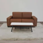 Brown-leather-sofa-and-white-coffee-table-on-beige-rug.